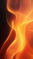 Flames dance gracefully in vibrant orange and yellow hues against a dark background photo