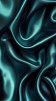 Soft teal satin fabric draping elegantly with rich texture and shimmering surface under diffused lighting photo