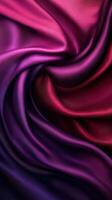 Colorful silk fabric draping in deep shades of purple and red with smooth texture and elegant flow photo