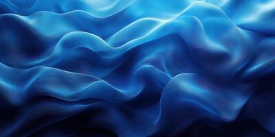 Fluid waves of deep blue fabric create an ethereal texture under soft lighting in a serene setting photo