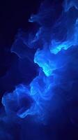 Abstract blue smoke swirling in dark background creating a mesmerizing visual effect photo