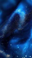 Shimmering blue fabric with intricate patterns reflecting light in a close-up view photo
