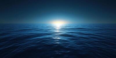 Calm ocean waves reflect the soft glow of a sunrise over the horizon at dawn photo