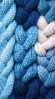 Textured knitted fabric with varying shades of blue and white intricately woven together photo