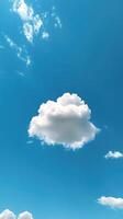 Fluffy white cloud drifting in a bright blue sky on a sunny afternoon photo