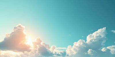 Bright sun rising behind fluffy clouds in clear blue sky during early morning hours photo