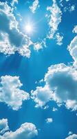 Bright blue sky with fluffy clouds and radiant sun shining above on a clear day photo