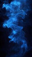 Swirling blue smoke against a dark background creates a mysterious and captivating atmosphere photo
