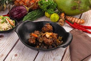 A bowl of food with meat, vegetables and a pineapple photo