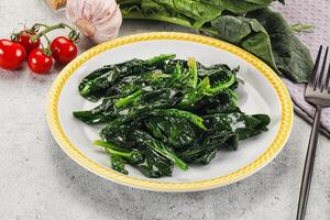 A plate of spinach with a fork and knife photo