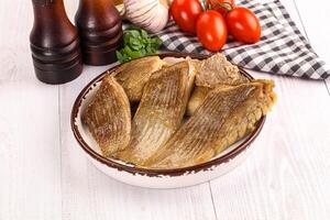 A bowl of fish with tomatoes and spices photo