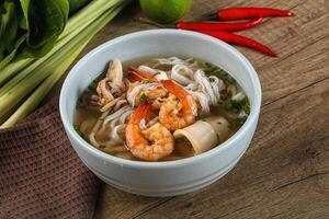 A bowl of soup with shrimp and vegetables photo