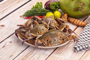 A plate of crabs on a table with other vegetables photo