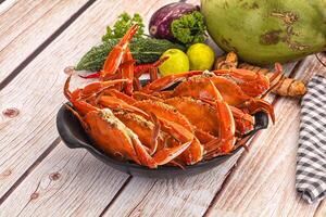 A bowl of crabs on a table with other food photo