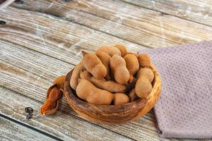 A bowl of peanuts on a wooden table photo