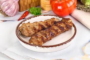 Two pieces of meat on a plate with vegetables photo