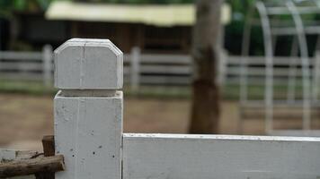 A white fence with a wooden post photo