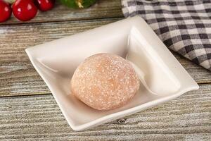 A white square dish with a cherry on top photo