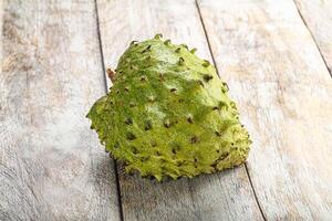 A green fruit on a wooden table photo