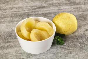 A white cup with sliced peaches and a leaf photo