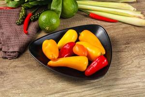 A bowl of peppers and other vegetables on a table photo
