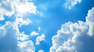Sunlight filtering through fluffy white clouds against a clear blue sky. The sky is a vibrant blue, with the sun shining brightly. photo