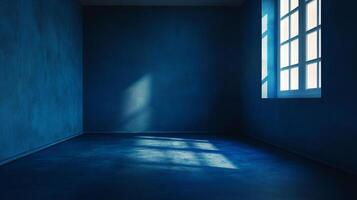 An empty blue room with light streaming through a window, creating shadows on the wall and floor, generating a tranquil atmosphere. photo