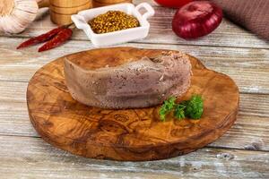 A piece of meat on a wooden cutting board with spices photo