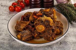 A bowl of meat and vegetables on a table photo