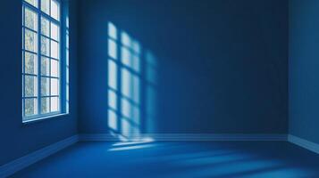 An empty blue room is filled with light streaming through a window, casting shadows on the wall and floor in a geometric pattern. photo