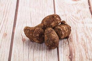 A pile of raw potatoes on a wooden table photo