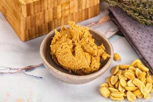 A bowl of peanut butter next to a wooden box photo