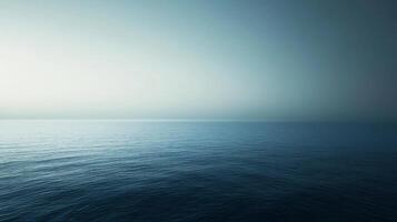 Calm ocean with a cloudy sky in the background. The water is blue and the sky is gray photo