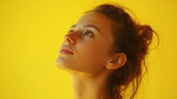 Woman gazes upwards. The bright background contrasts with her fair skin and brown hair, creating an optimistic, hopeful portrait. photo