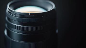 Close-up of a photographic lens against a dark backdrop showcasing the details of its textured rings and smooth reflective surface. photo