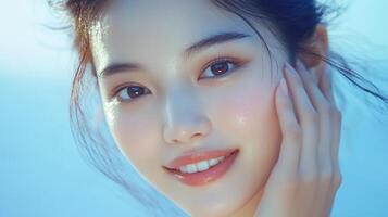 Radiant portrait of a young woman showcasing glowing skin, delicate makeup, and a soft, ethereal beauty against a serene blue background. photo