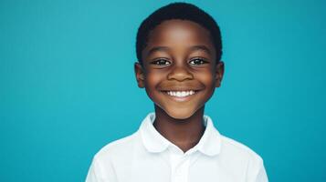 Smiling boy with a heartwarming grin against a vibrant blue backdrop, radiating joy and innocence in a captivating portrait. photo