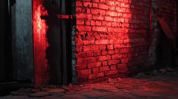A dimly lit alleyway is illuminated with a striking red glow, casting shadows against the aged brick wall and weathered wooden door. photo