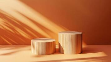 Two wooden cylinder pedestals are displayed in a warmly colored studio setting with dappled shadows, ideal for product showcase or artistic display. photo