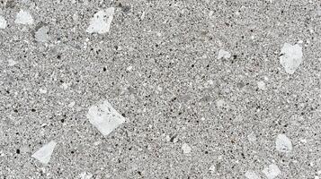 Detailed grey terrazzo stone with a mix of speckles and larger fragments, creating a textured surface for flooring or countertops. photo