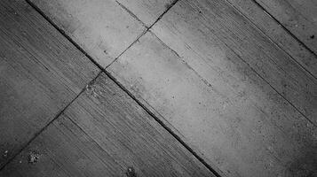 Monochrome close-up reveals textural complexity of weathered concrete surface with diagonal patterns, enhanced light and shadow. photo