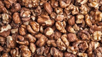 A tightly packed collection of walnut pieces. The nuts are a mix of halves and smaller bits, creating a dense, textured surface. photo