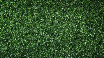 An overhead shot displays a uniform expanse of green artificial turf. The closely cropped blades create a dense, vibrant, and textured surface. photo