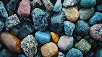 Collection of smooth, colorful rocks of various sizes and textures, creating an earthy and organic pattern. Variety of colors and shapes photo