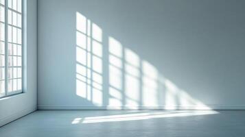 An empty room awash with sunlight streaming through a large window, creating geometric patterns on the wall and floor. photo
