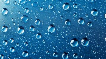 Macro photography of water droplets resting on a sleek, textured, vibrant blue surface, displaying a captivating interplay of light and shadow. photo