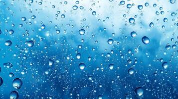 Captivating water droplets cling to a cool blue surface, creating a mesmerizing dance of light and reflection in a refreshing aquatic scene. photo