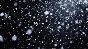 A blizzard of white snow on a black background. The snow is dense and obscures most of the view, creating a winter scene. photo