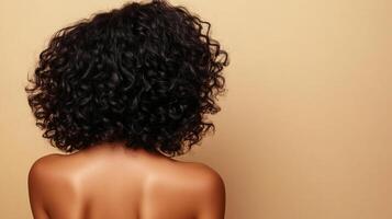 Back of woman with curly black hair against a neutral background, showcasing natural texture and beauty, ideal for hair or skin care ads photo