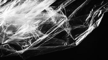 Abstract monochrome photo showcasing the interplay of light and shadows on translucent plastic against a stark black background.